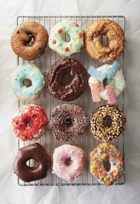 Dutzende bunte Donuts frisch gebacken und dekoriert — Stockfoto