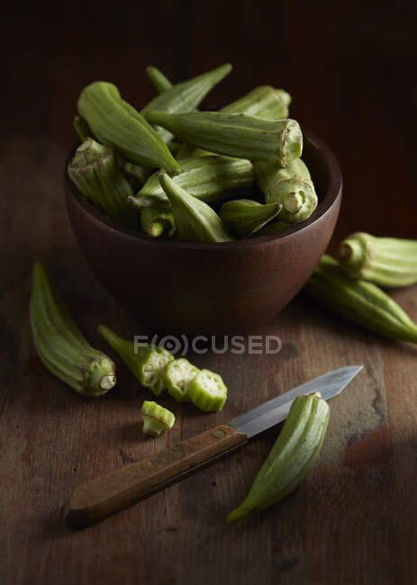 Bowl of Okra with Knife on Cutting Board — Stock Photo