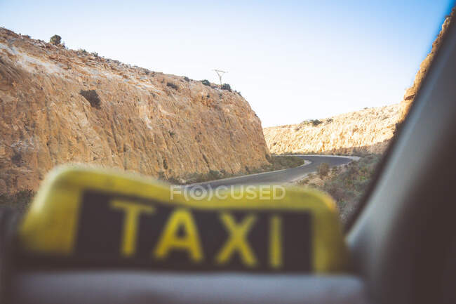 A taxi drives on the road between cliffs — Stock Photo