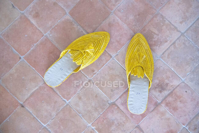 Zapatillas amarillas en un suelo de ladrillo - foto de stock
