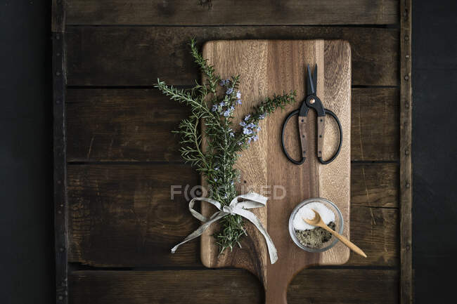 Pacco di rosmarino fresco, sale grosso, forbici su taglieri — Foto stock