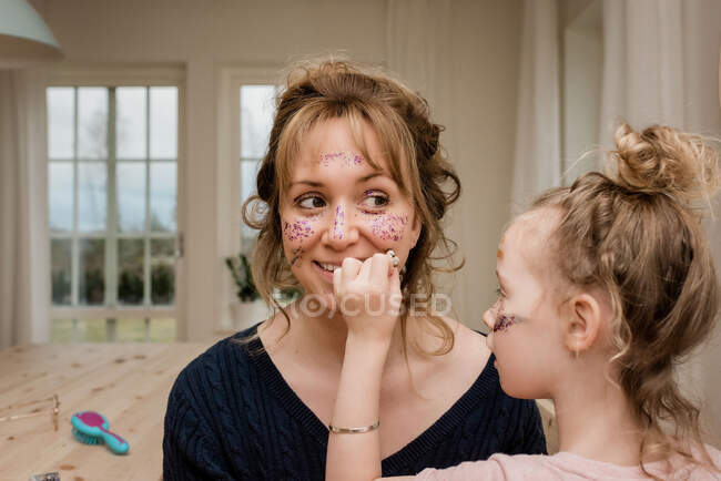 Mom and daughter playing with make up and dress up at home — Stock Photo