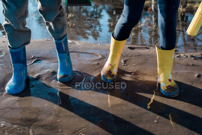 Stivali da pioggia per bambini che giocano nella sabbia e nel mare in Svezia — Foto stock