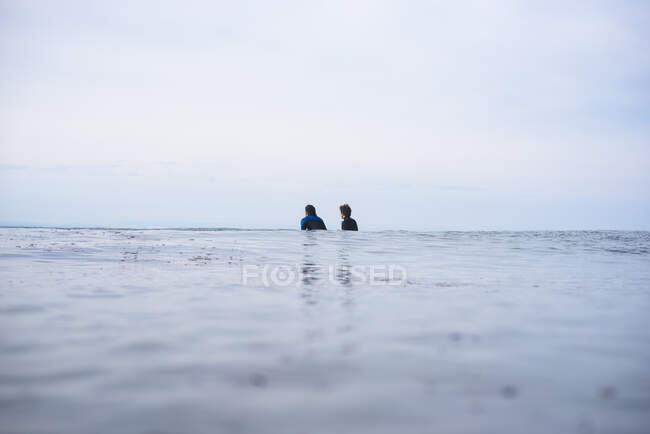 Dois amigos à espera de ondas no oceano — Fotografia de Stock
