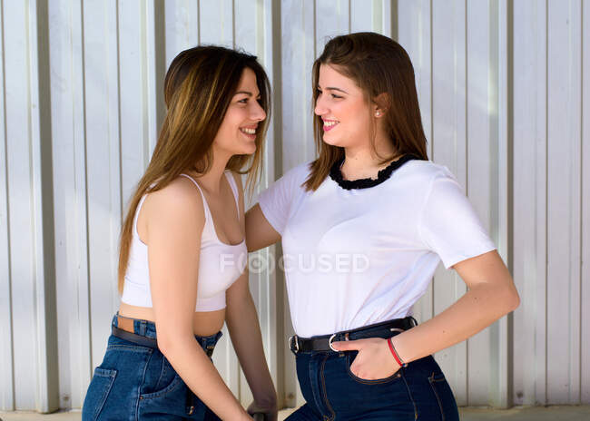 Дві гарні європейські дівчини в футболках і джинсах дуже близько одна до одної для камери. — стокове фото