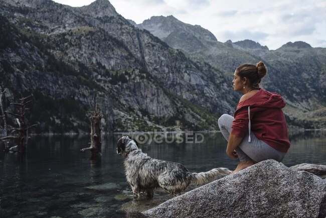 Mujer con perro en el lago - foto de stock