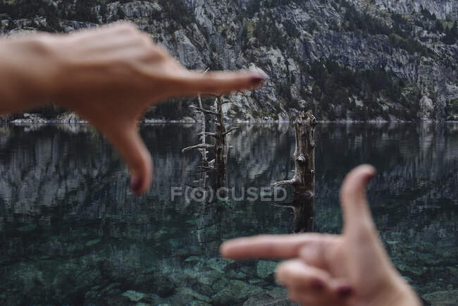Unfocused woman's hands framing some trees in a mountain landscape. — Stock Photo