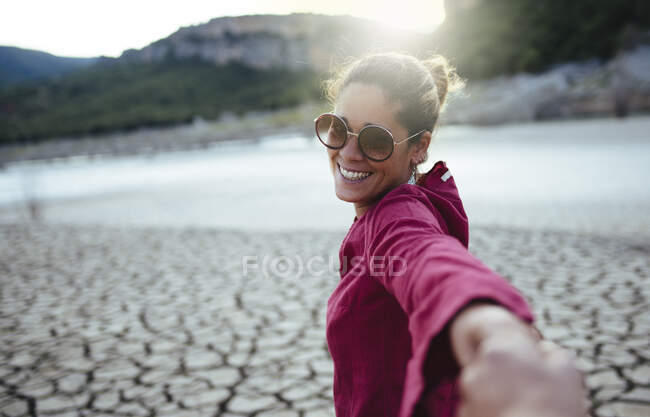 Sorrindo mulher segurando sua mão para o namorado olhando para a câmera — Fotografia de Stock