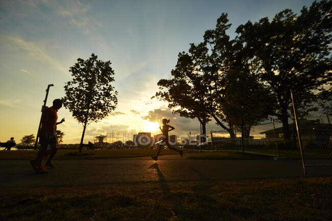 Die Silhouette einer Frau, die bei Sonnenuntergang in Boston läuft. — Stockfoto