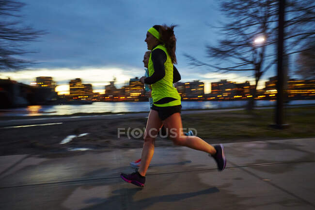 Os corredores aceleram em um crepúsculo ao longo do Charles em Boston. — Fotografia de Stock