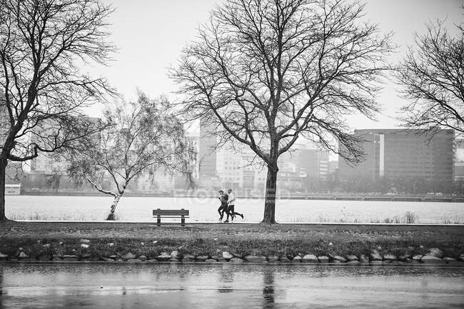 Un gruppo corre sotto la pioggia fredda lungo il fiume Charles a Boston. — Foto stock