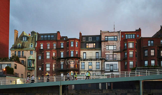 Un groupe monte une rampe devant une rangée de maisons en grès brun de Boston. — Photo de stock