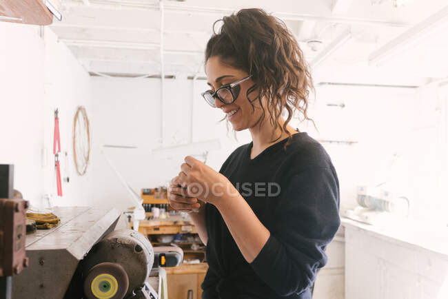Junge Frau arbeitet in Werkstatt — Stockfoto