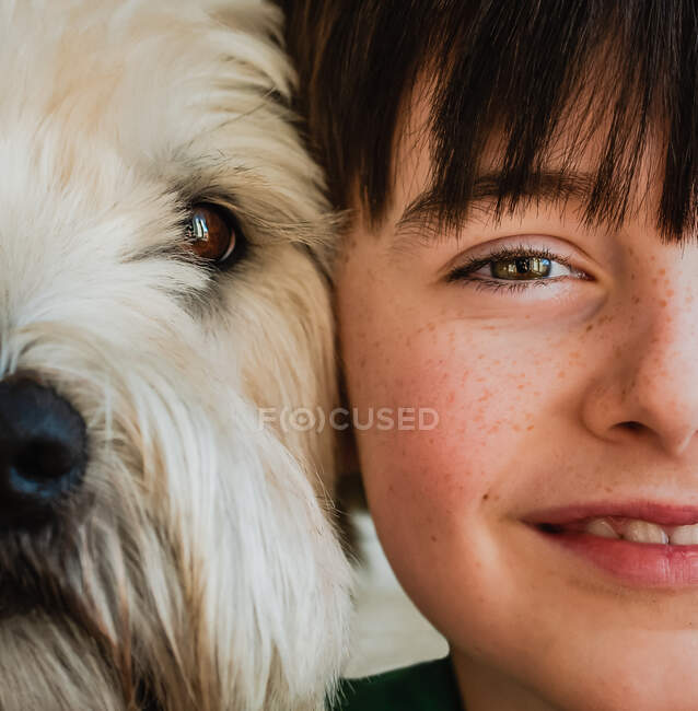 Close up of half of the faces of boy and his dog with heads together. — Stock Photo