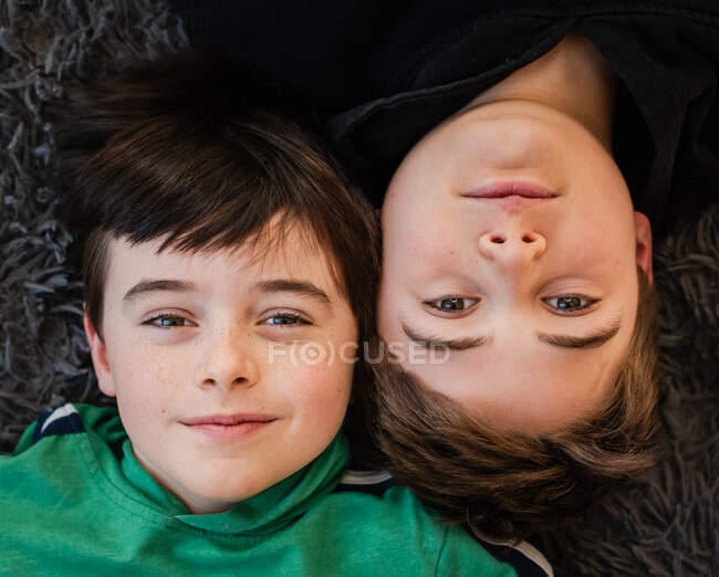 Дивлячись вниз на обличчя двох хлопчиків, що лежать один біля одного . — стокове фото