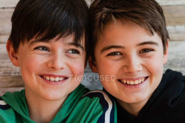 Close up de dois garotos sorridentes com as cabeças juntas. — Fotografia de Stock