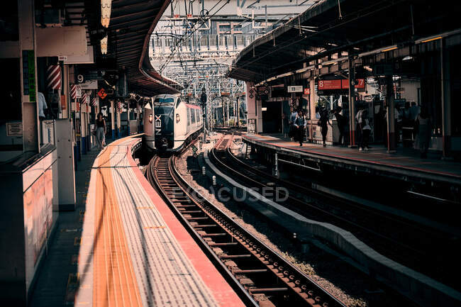 Um trem chega à estação de trem suburbana de tokio de manhã — Fotografia de Stock