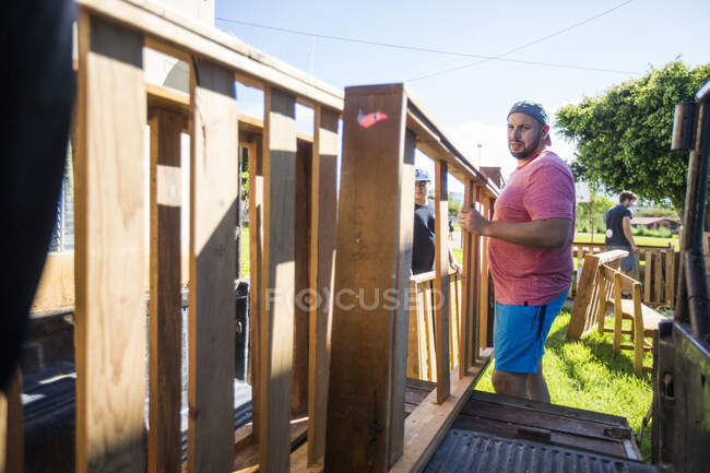 Movers carregar móveis de madeira na parte de trás de um caminhão pickup — Fotografia de Stock