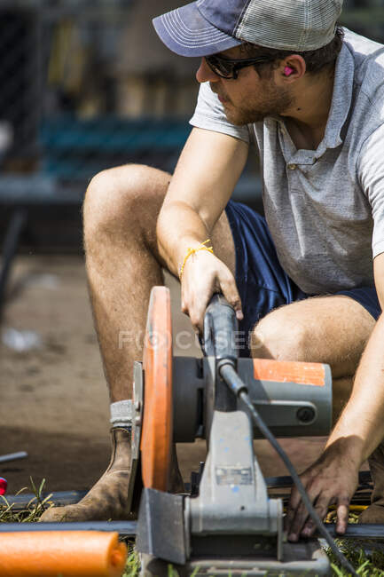 Fecho do trabalhador qualificado usando serra de corte para cortar aço — Fotografia de Stock