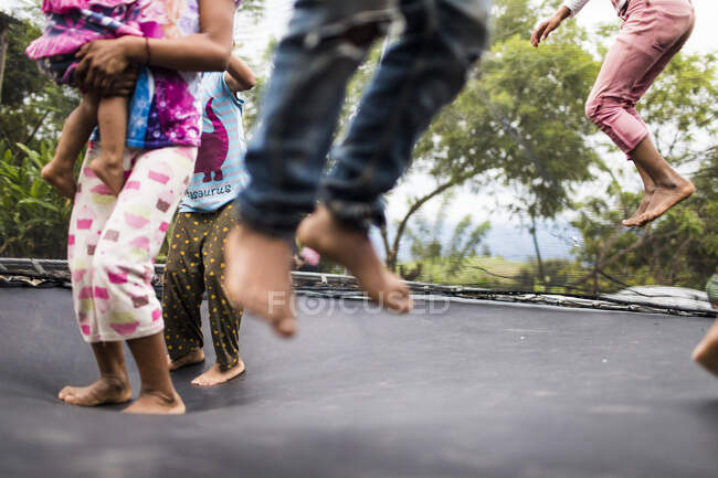 Crianças pulando em um trampolim quintal — Fotografia de Stock
