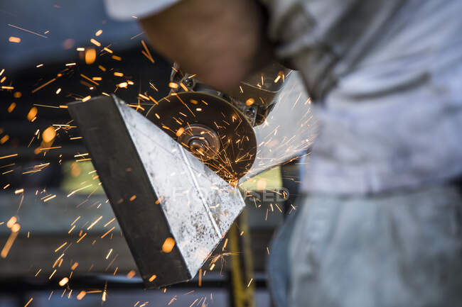 Nahaufnahme eines Arbeiters mit Winkelschleifer in einer Fabrik — Stockfoto