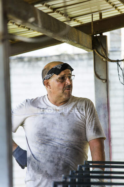 Retrato de un trabajador del metal de pie en el taller con camisa sucia. - foto de stock