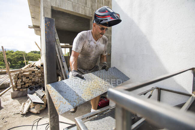 Homem trabalha no canteiro de obras, edifício escadaria — Fotografia de Stock