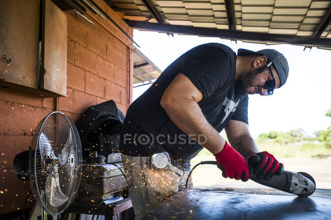 Worker concentrating, using angle grinder to cut steel. — Stock Photo