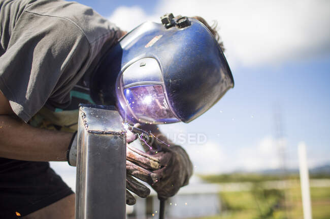 Man welding outdoors on a rooftop — Stock Photo