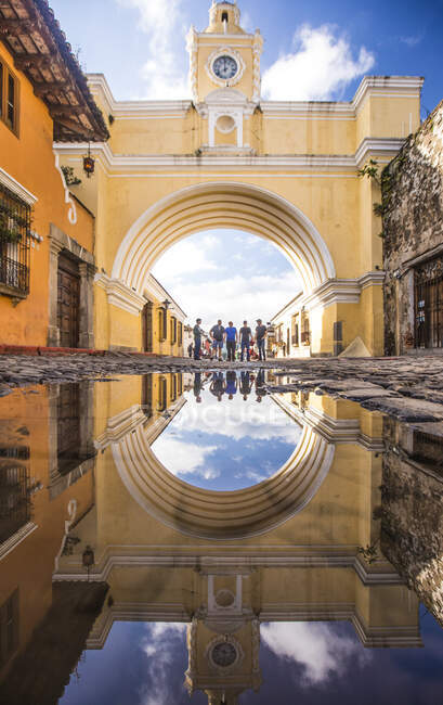 Туристы стоят под аркой Санта-Каталина в Антигуа, Гватемала — стоковое фото