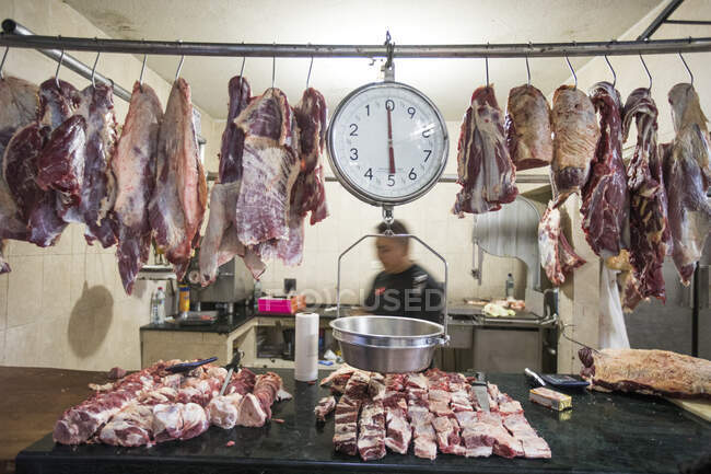 Carne e balança pendurada em um açougue — Fotografia de Stock