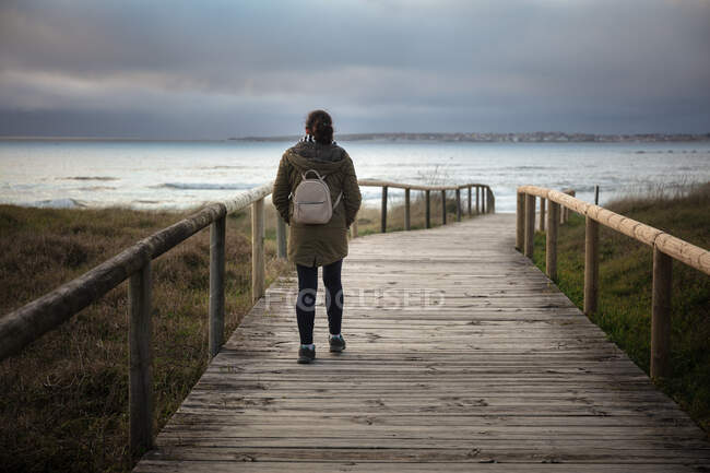 Mulher caminhando por uma bela área de dunas na costa — Fotografia de Stock