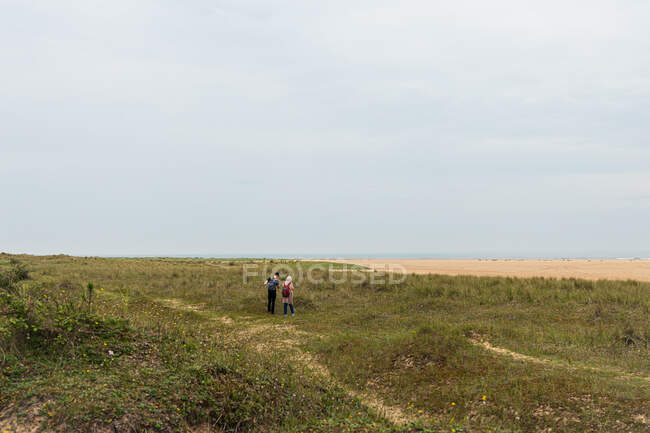 2 человека, прогуливающиеся вдоль побережья Норфолк — стоковое фото