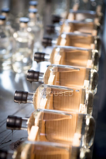 Bottles of liquor being capped at a distillery. — Stock Photo