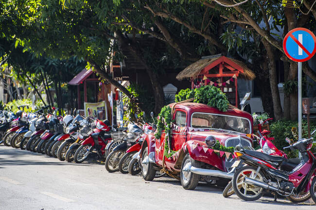 An einer Straße in Luang Prabang geparkte Motorräder und Oldtimer — Stockfoto