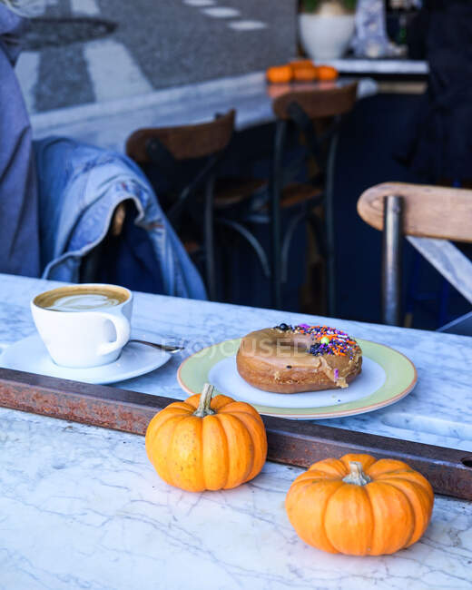 Morning cafe essentials with a coffee and donut. — Stock Photo