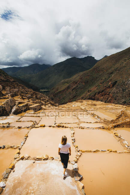 Giovane donna è in piedi vicino alle famose miniere di sale in Perù — Foto stock
