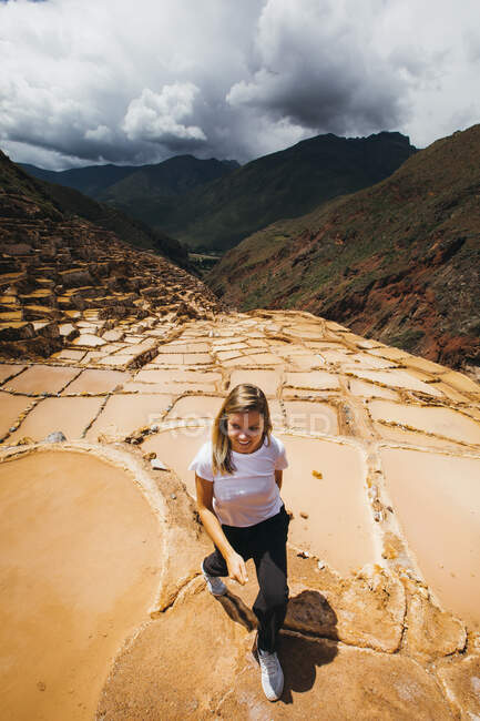 Giovane donna cammina vicino alle famose miniere di sale in Perù — Foto stock