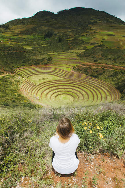 Uma jovem está sentada perto da famosa mancha peruana Moray no Peru — Fotografia de Stock