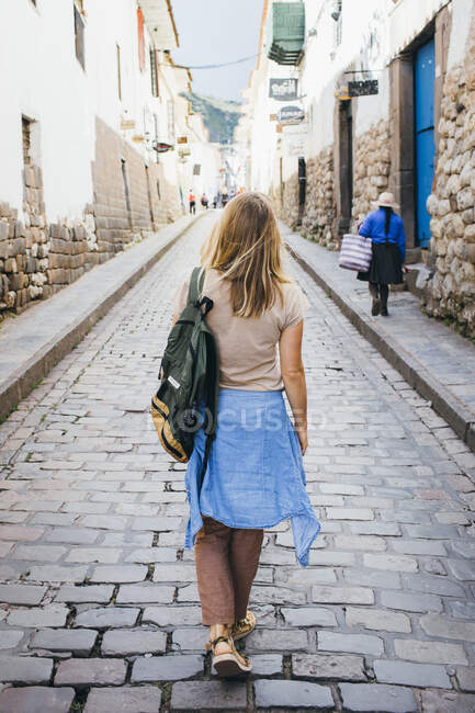Une jeune femme marche dans la rue de la ville de Cusco, Pérou — Photo de stock