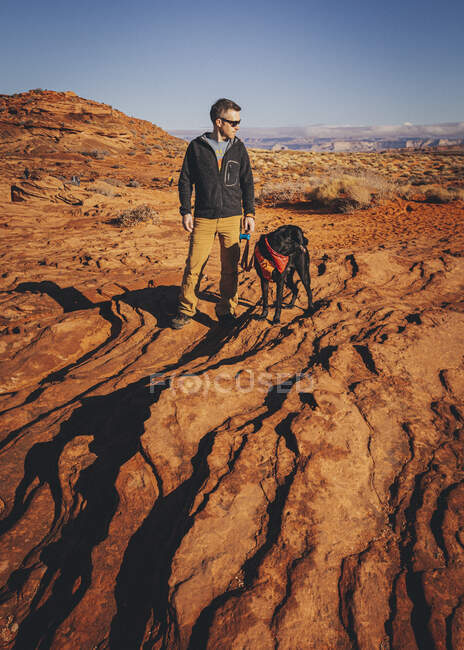 Un uomo con un cane è in piedi vicino Horseshoe Bend, Arizona — Foto stock