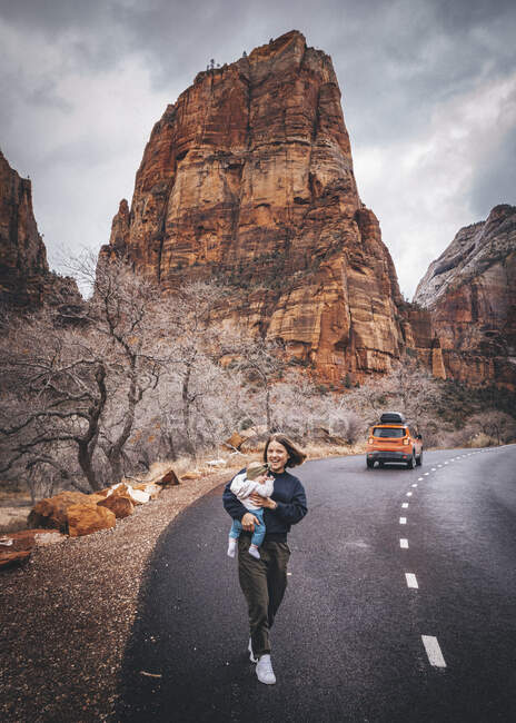 Una mujer con un hijo está caminando en el Parque Nacional Zion, Utah - foto de stock
