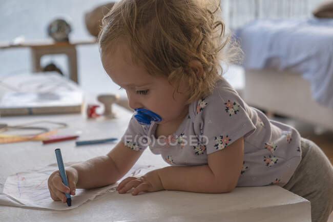 Kleines Mädchen zeichnet mit Farben im Zimmer des Hauses. — Stockfoto