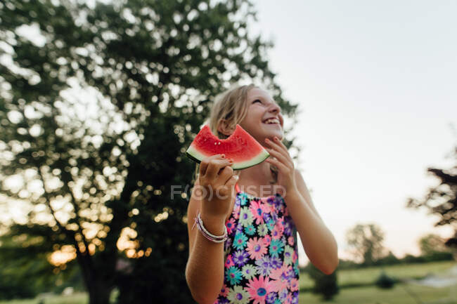 Junges Mädchen mit breitem Lächeln isst Wassermelone im Sommer draußen — Stockfoto