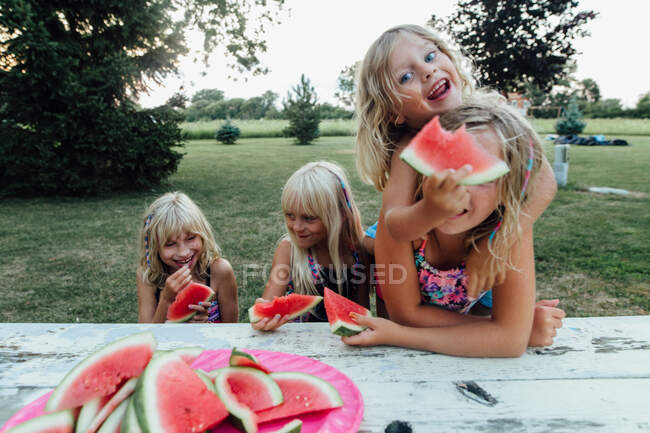Children being silly eating watermelon outside in the summer — Stock Photo