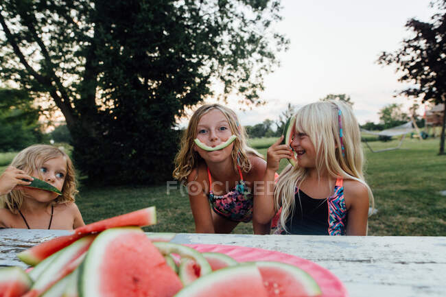 Kleine Kinder albern, während sie im Sommer draußen Wassermelone essen — Stockfoto