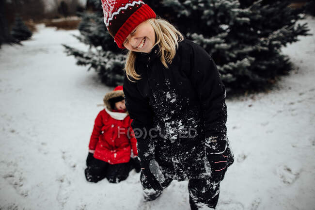Молода дівчина сміється під час гри в сніг — стокове фото
