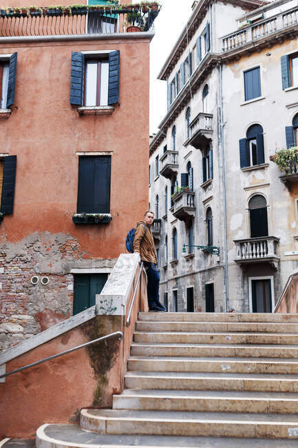 Young blond guy in a brown jacket in middle of streets of Venice — Stock Photo