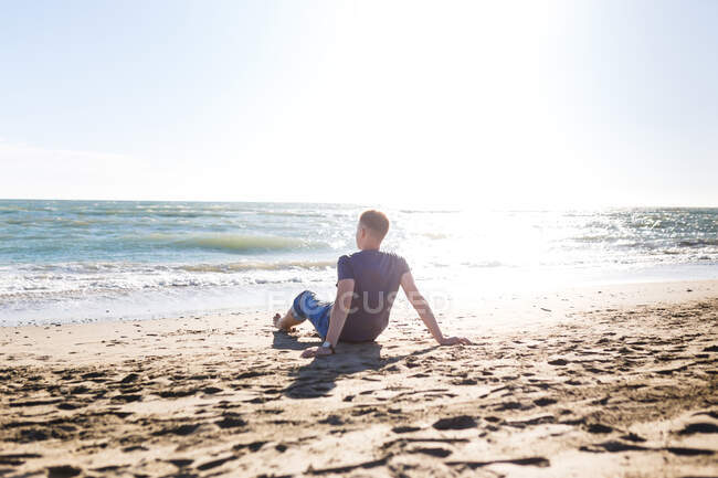 Blond guy tourist in jeans enjoying the beach and the sea — Stock Photo