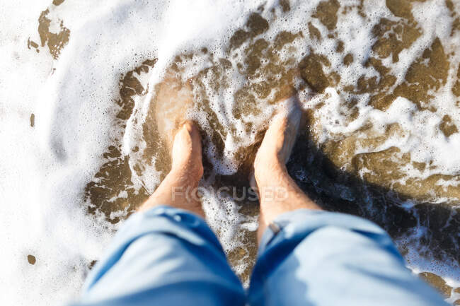 Biondo ragazzo turista in jeans godendo la spiaggia e il mare — Foto stock